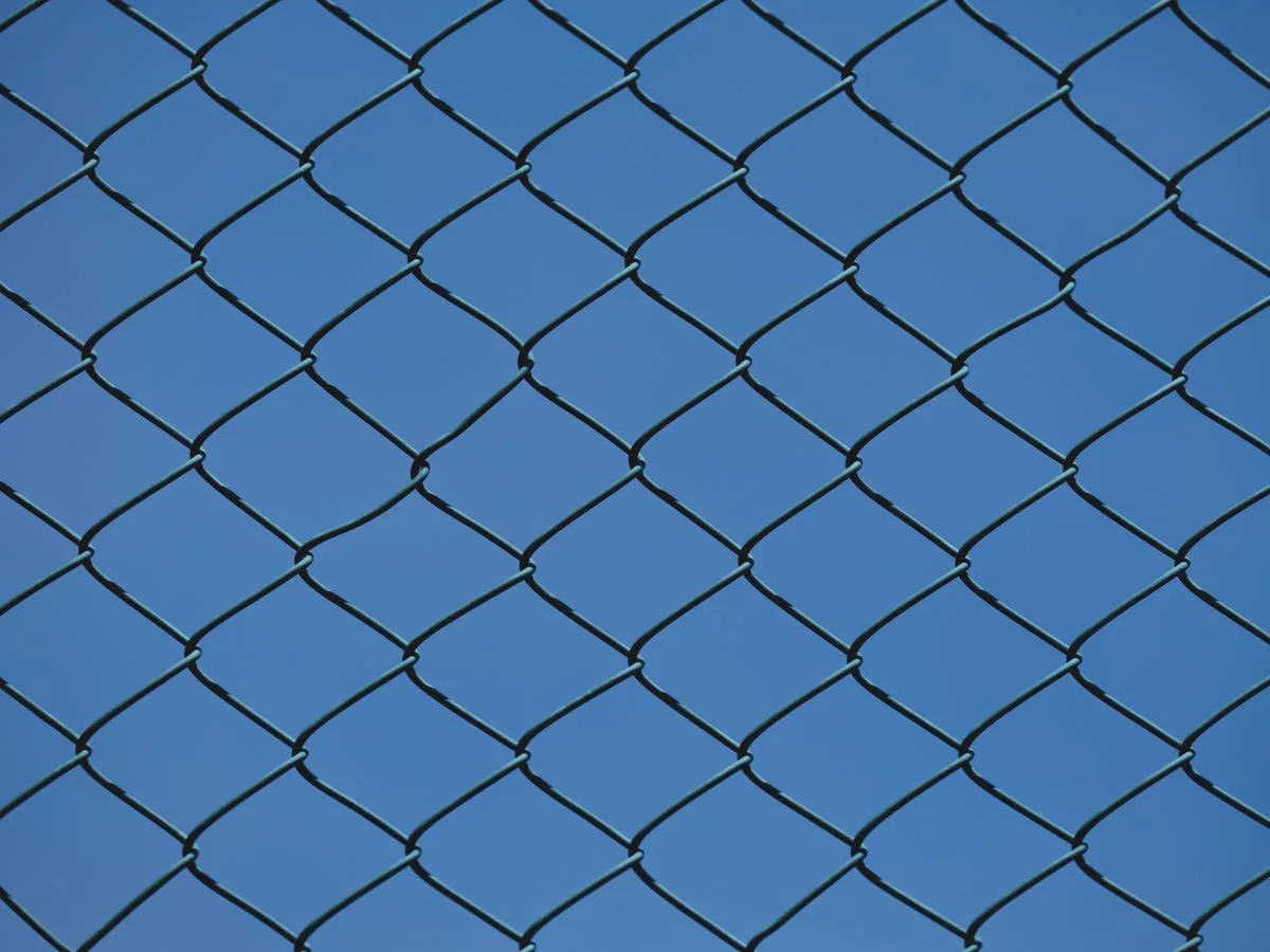 Chain link fence fabric against a clear blue sky