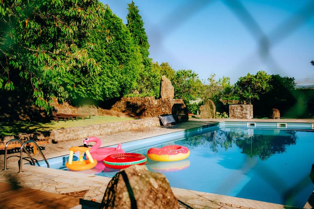 Backyard swimming pool seen through a perimeter fence