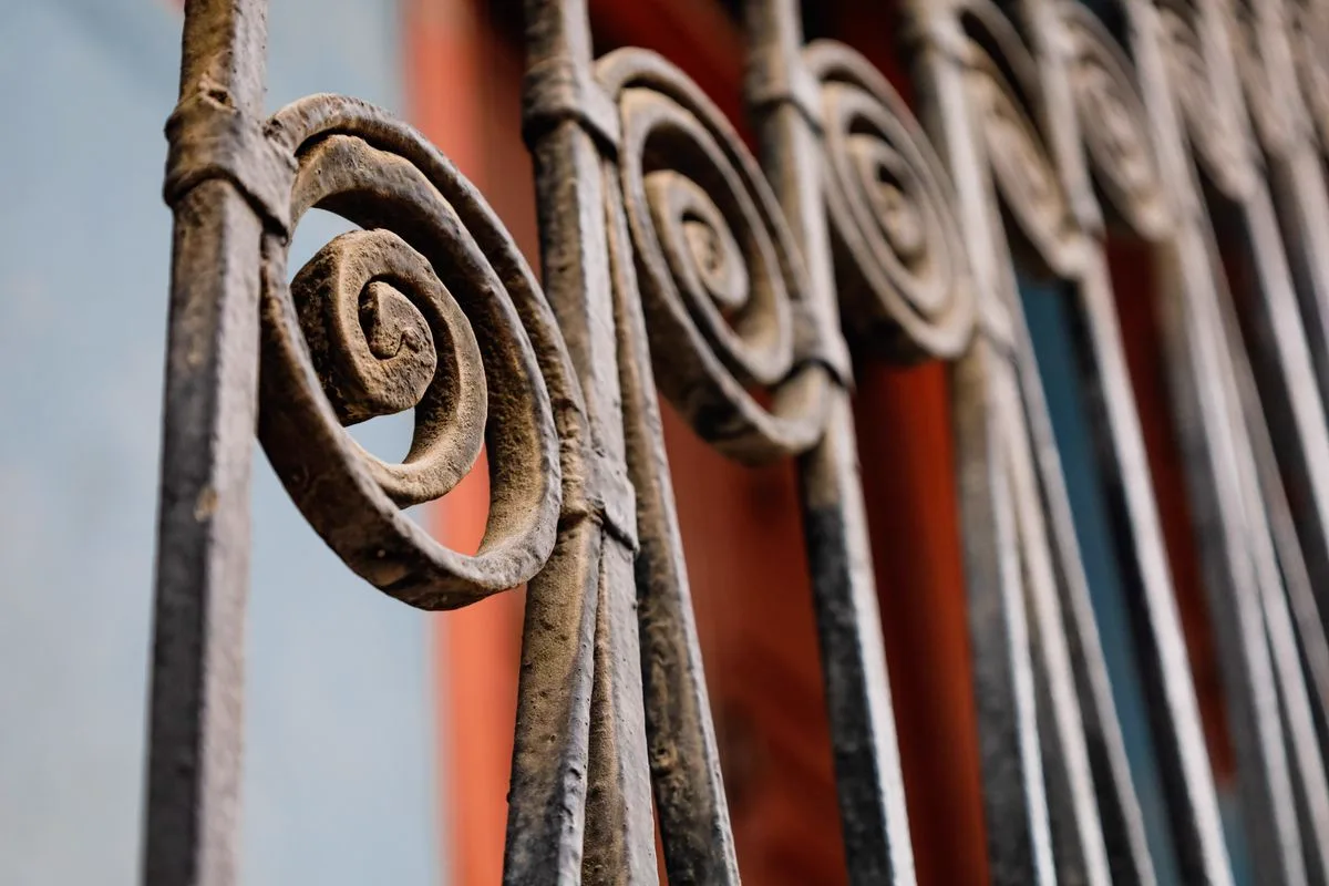 Hand-forged iron fence scrollwork in detail